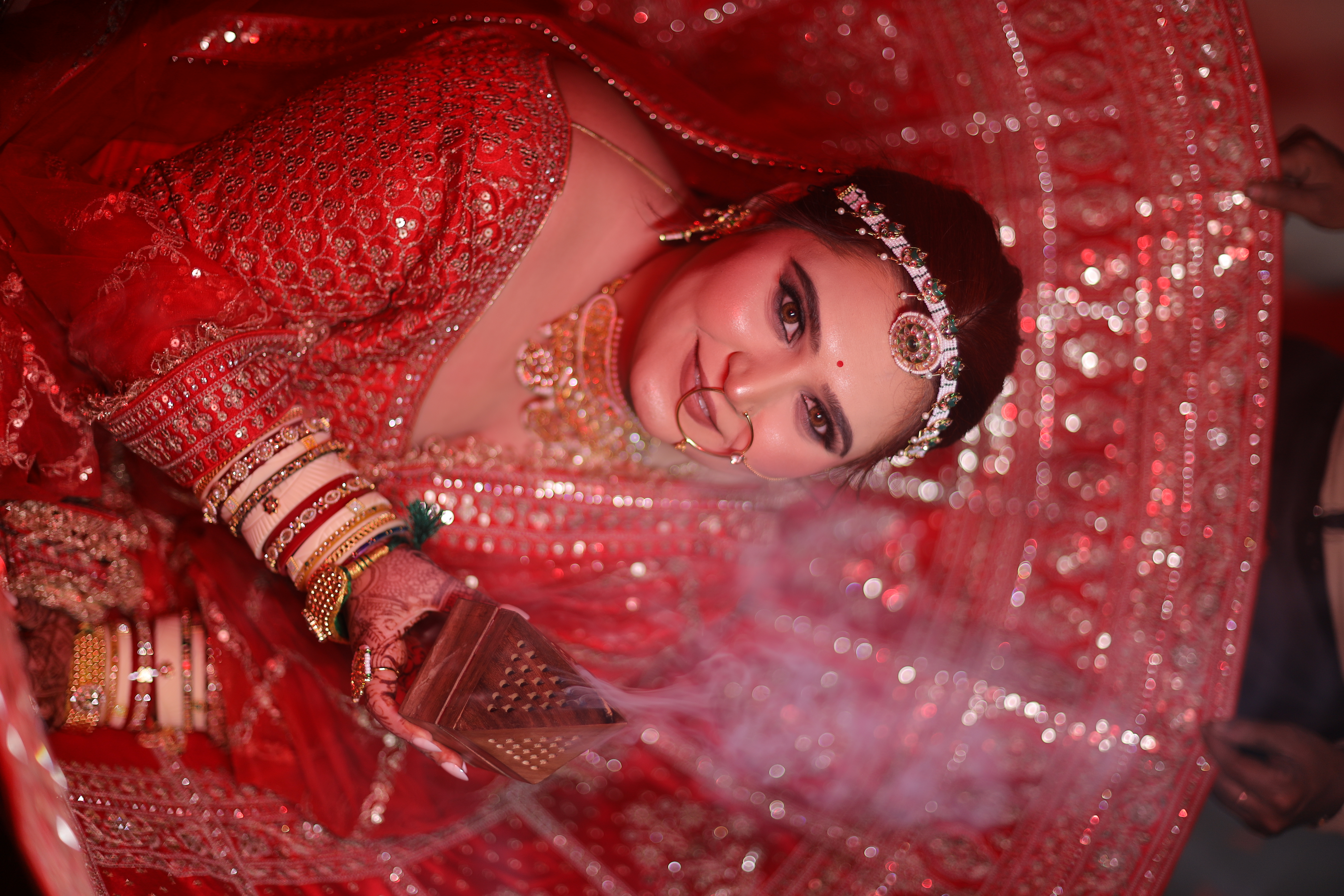 Ceremonial bridal portrait with traditional incense dhoop and deep crimson zardozi lehenga